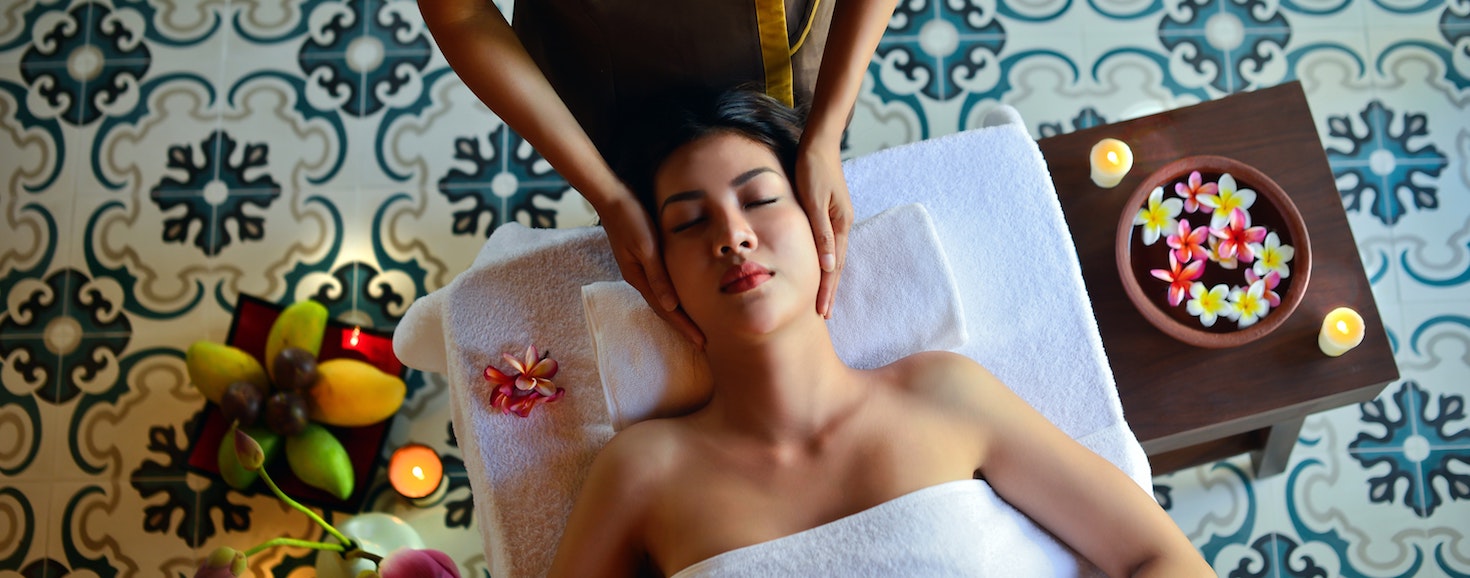 a massage for a woman in a spa tends 2020